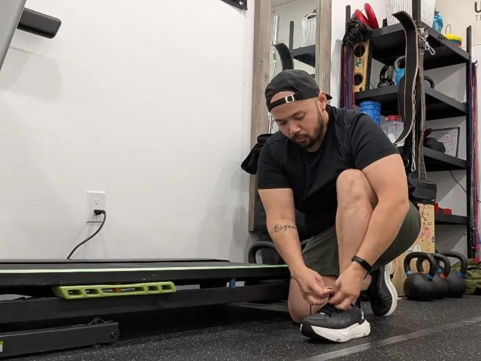 Lester Hernandez ties shoe before going on run in preparation for Manitoba Marathon